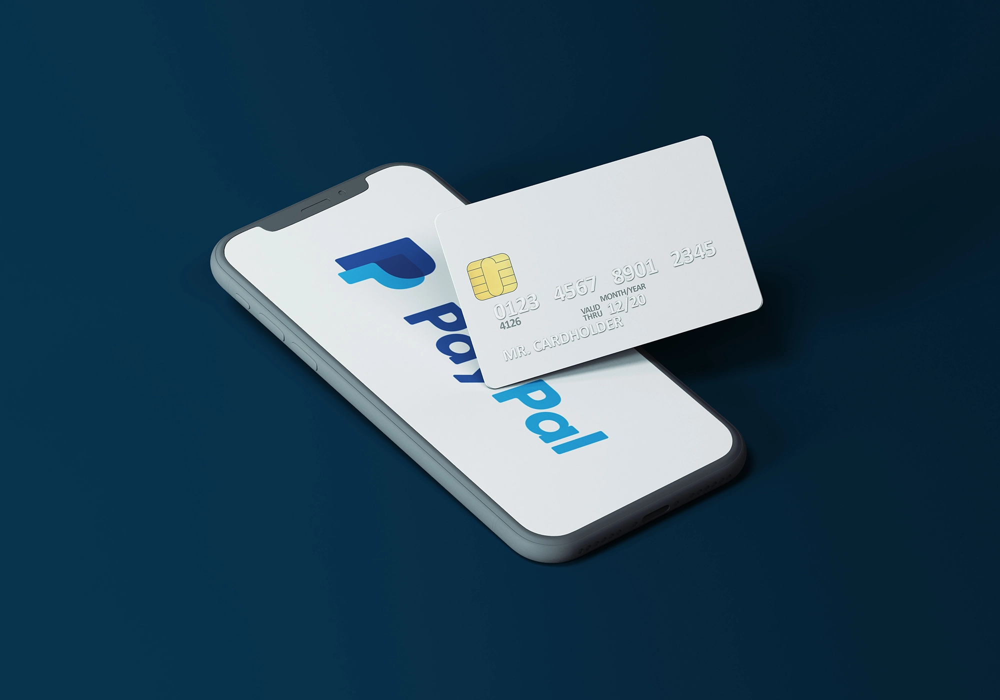 Portable avec un fond d'écran Paypal avec une carte de crédit blanche posées dessus.